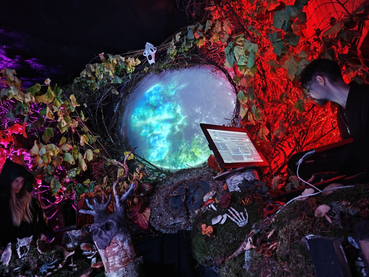 VJing a portal circled with branches like a nature portal, sculpture of skull with horn antlers reaching towards portal entrance