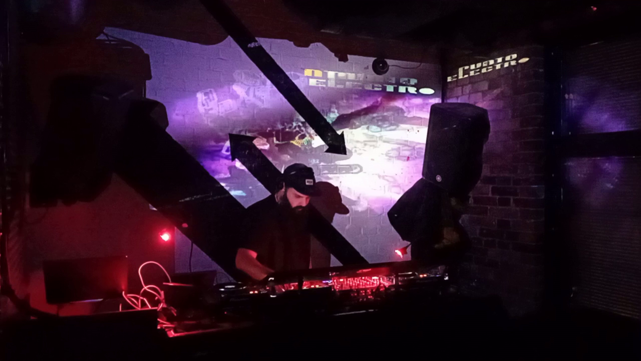 Punto Electro live set, video projection on brick wall, punto electro logo on 2 walls surfaces, spaceship glowing in projection